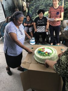 Woman standing and cutting a birthday cake in the San Ramón Christian base community, where communion was celebrated with cake as the communion element. 