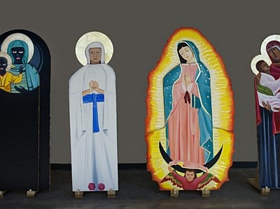 Four life-size cutout images different depictions of Mary in different attire.