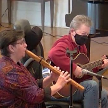 Chrys playing a Navaho flute and Pam playing guitar.erform on