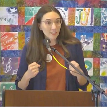 Melissa preaching on Oct. 1, 2023 in front of a colorful patchwork quilt.
