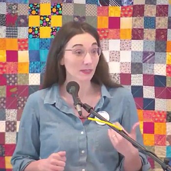 Melissa preaching in front of a colorful quilted background.