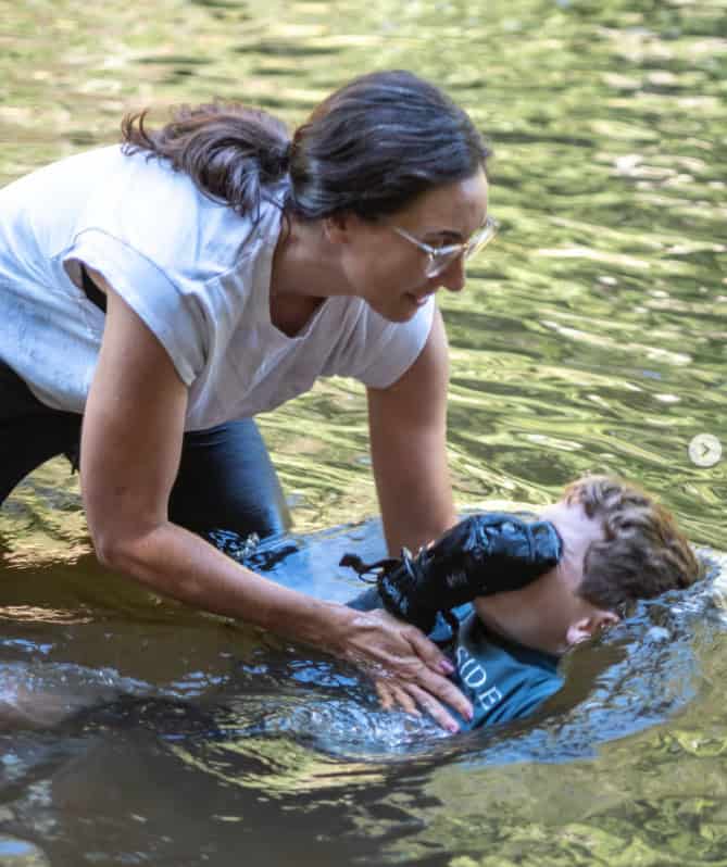 Pastor Melissa dunking young person in the river during baptism.
