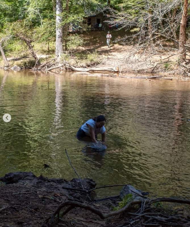 Pastor Melissa in the Eno River with her son, baptizing him.
