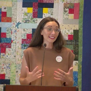 Melissa expressing an idea with her hands while speaking at RMC on July 27, 2025.