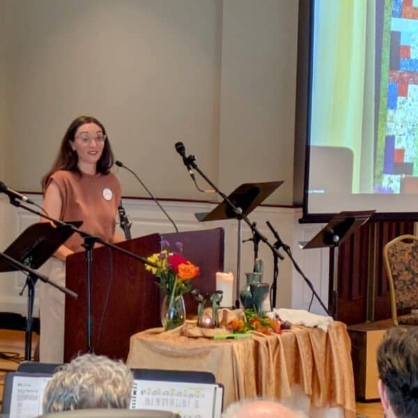 Melissa preaches her final sermon at RMC with her image projected on the screen beside her.