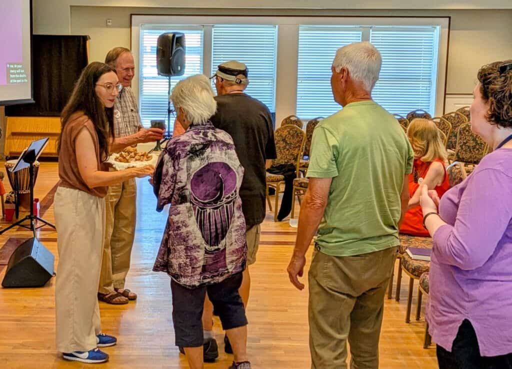 Melissa and Hans serve communion to folks as others wait in line.