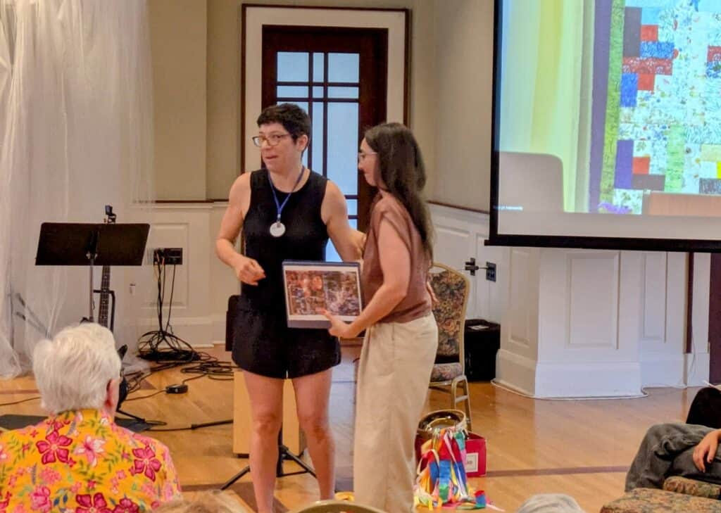 Jackie presents Melissa with a binder book of memories contributed by RMCers.