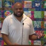 Trey speaking in front of a colorful banner on June 14, 2026.